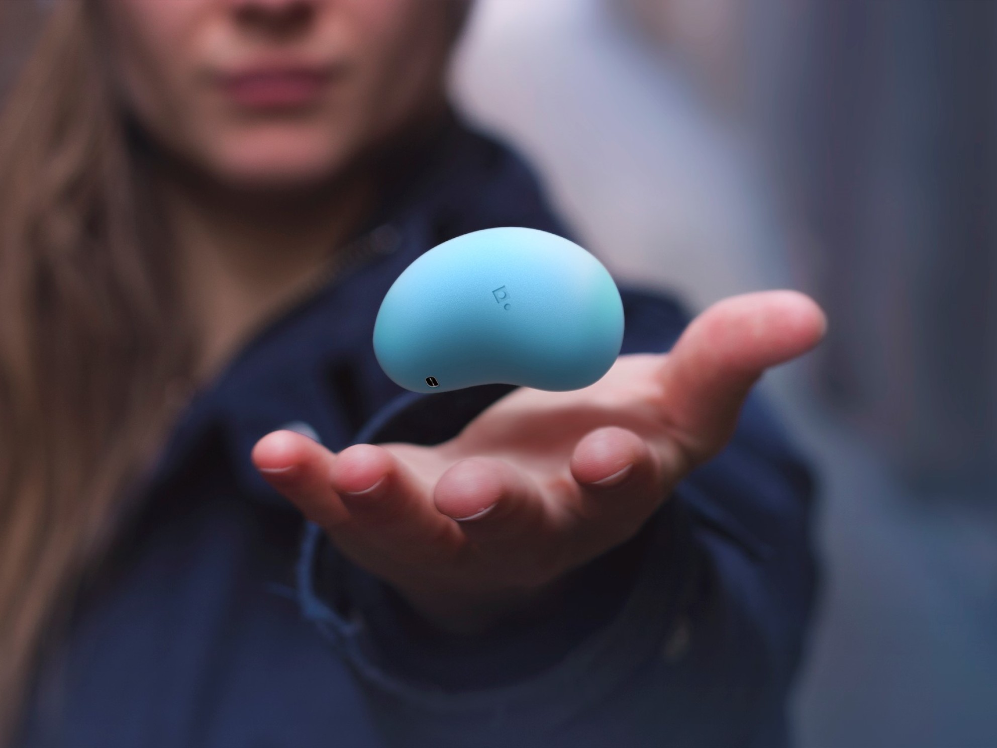 Woman shows a hand-held tool, developed by Grasp, which records a patient's experiences during treatment.