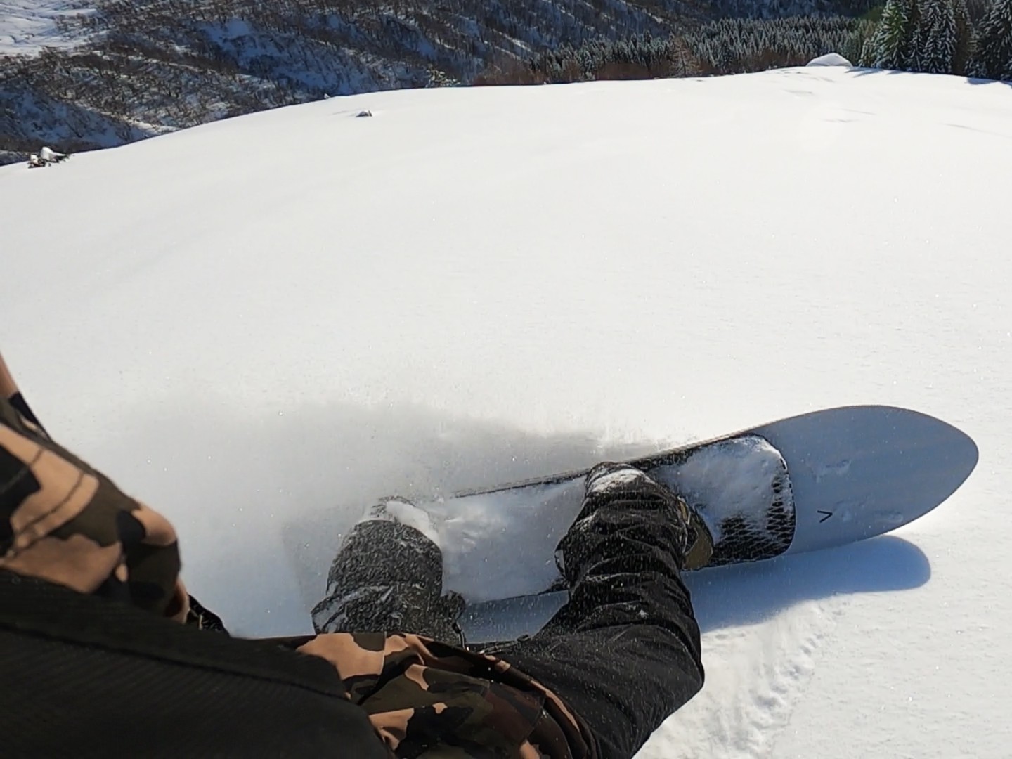 Person med snøbrett i en snøkledt fjellskråning