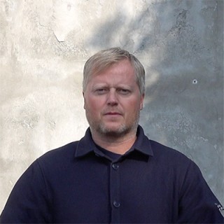 Nærbilde av en blond mann med mørkeblå skjorte
