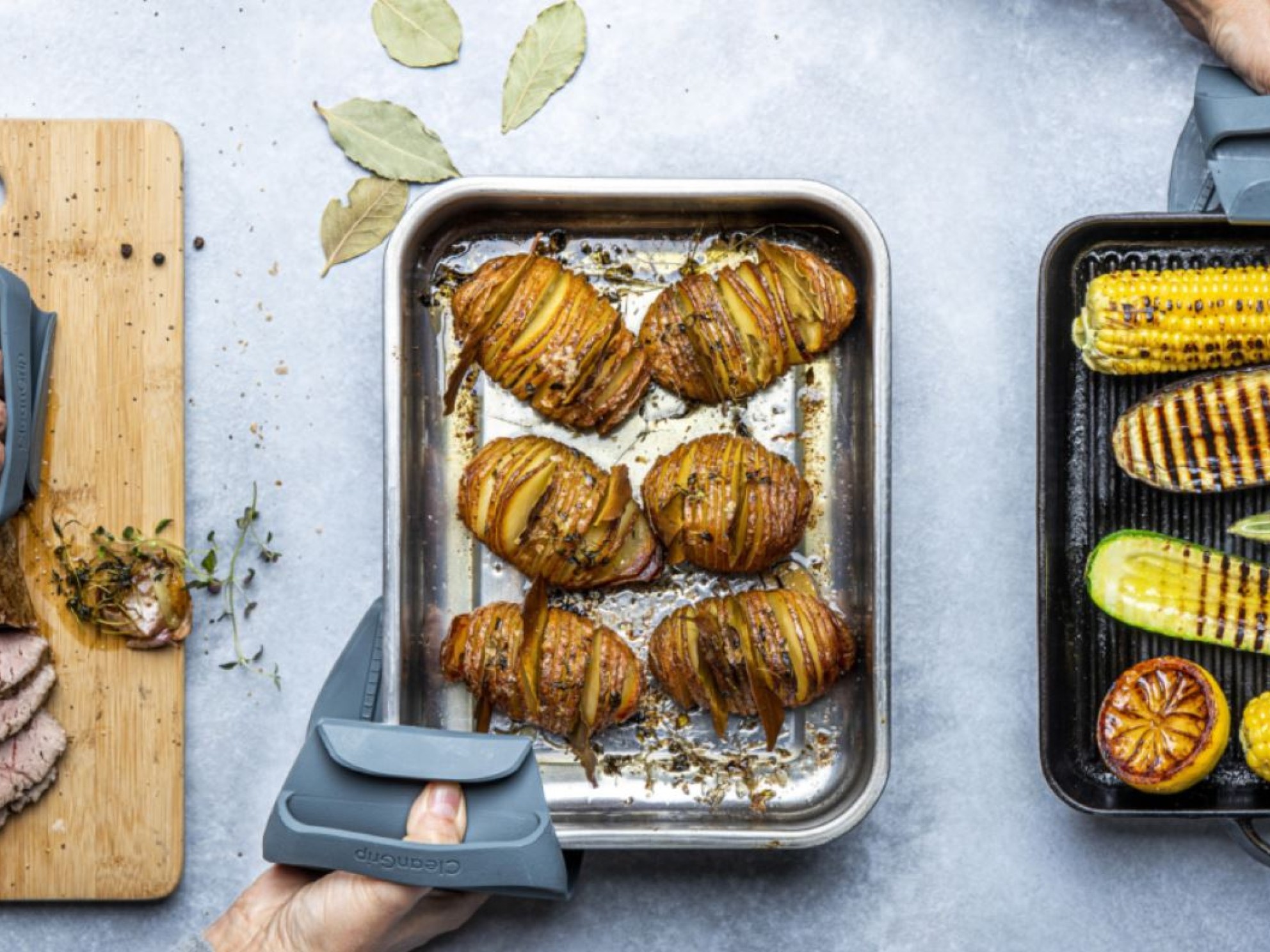 Kitchen utensils from CleanGrip are used to hold a metal form with food.